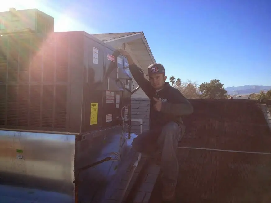 HVAC technician performing Heat Pump Repair on a rooftop unit in Eatonton